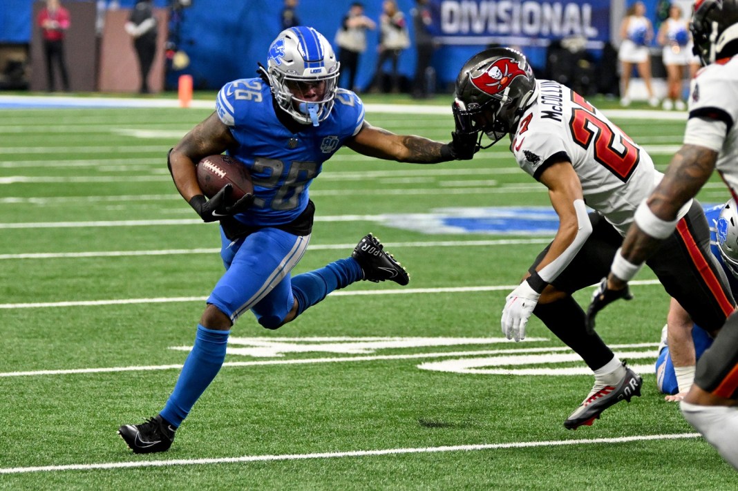 Detroit Lions running back Jahmyr Gibbs (26) runs with the ball against Tampa Bay Buccaneers cornerback Zyon McCollum (27)