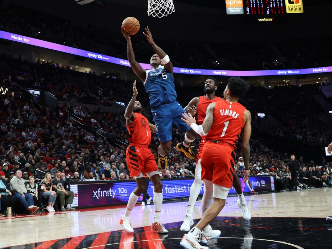 Timberwolves' Anthony Edwards shoots over Blazers' Jerami Grant, Deandre Ayton, and Anfernee Simons.