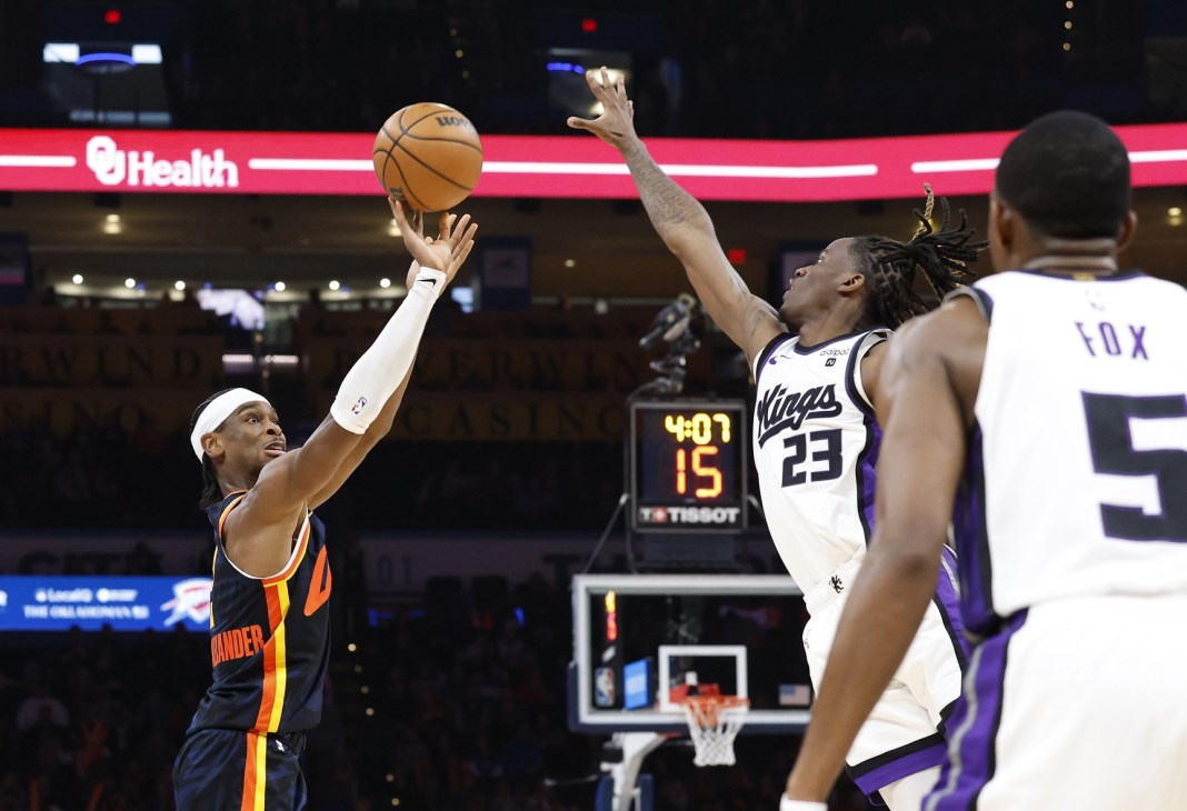 Oklahoma City Thunder guard Shai Gilgeous-Alexander shoots as Sacramento Kings guard Keon Ellis defends.