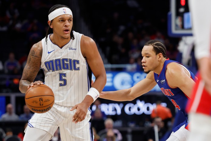 Orlando Magic forward Paolo Banchero dribbles defended by Detroit Pistons forward Kevin Knox II in the first half at Little Caesars Arena.