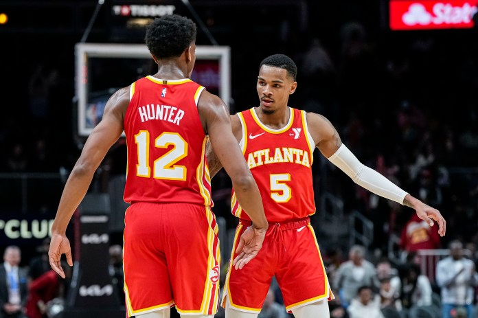 Atlanta Hawks forward De'Andre Hunter and guard Dejounte Murray react after defeating the Orlando Magic at State Farm Arena.