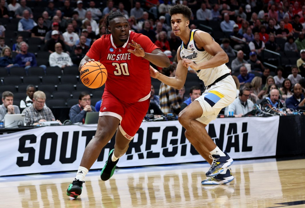 North Carolina State Wolfpack forward DJ Burns Jr. drives against Marquette Golden Eagles forward Oso Ighodaro in the 2024 NCAA Tournament.