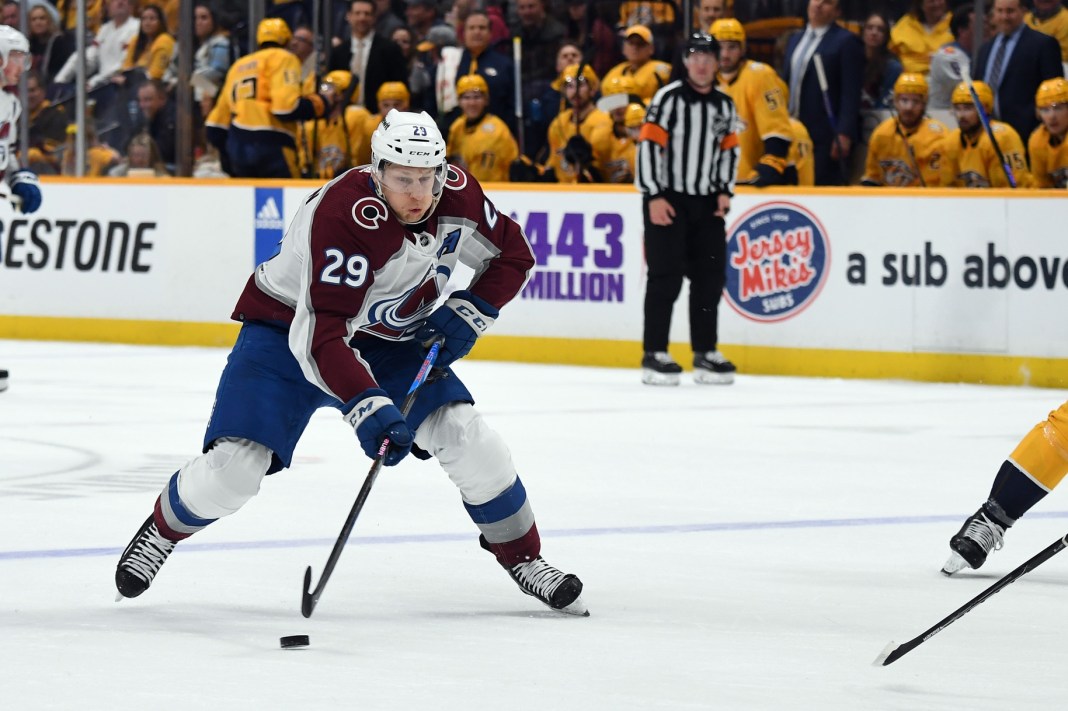 Colorado Avalanche center Nathan MacKinnon plays the puck against Montreal Canadiens' Mike Matheson.