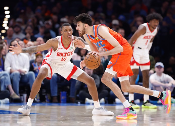 Oklahoma City Thunder forward Chet Holmgren moves the ball as Houston Rockets forward Jabari Smith Jr. defends.