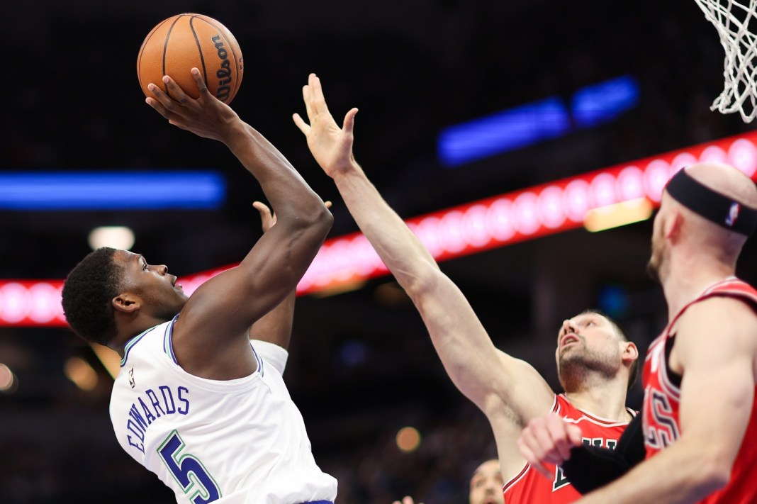 Minnesota Timberwolves guard Anthony Edwards (5) shoots as Chicago Bulls center Nikola Vucevic (9) defends during the first half at Target Center