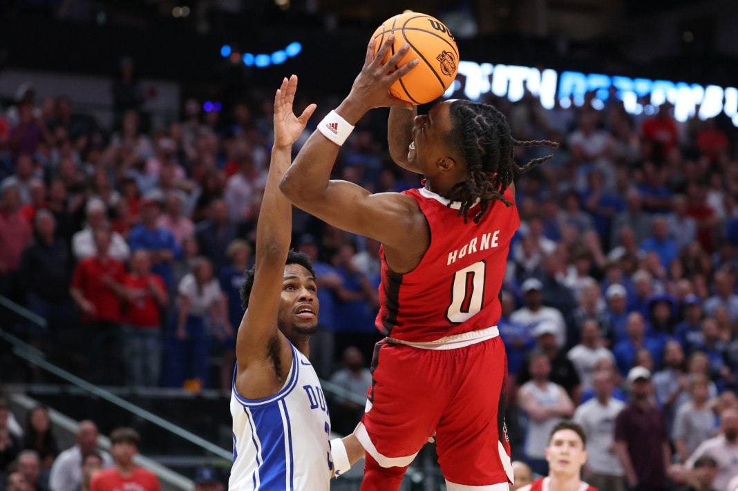 North Carolina State Wolfpack guard DJ Horne shoots against Duke Blue Devils guard Jeremy Roach in the 2024 NCAA Tournament.