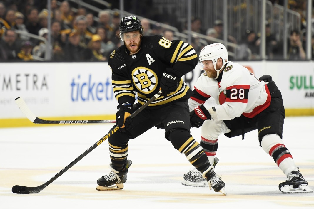 Boston Bruins right wing David Pastrnak controls the puck while Ottawa Senators' Claude Giroux defends.