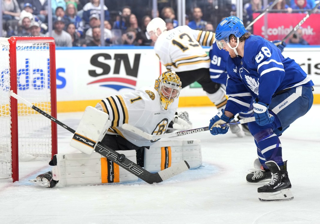 Toronto Maple Leafs right wing William Nylander battles for the puck in front of Boston Bruins goaltender in the 2024 Stanley Cup Playoffs.