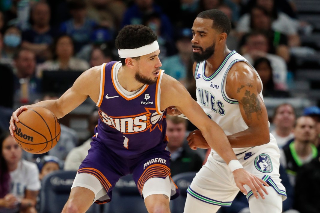 Phoenix Suns guard Devin Booker works around Minnesota Timberwolves guard Mike Conley in the third quarter at Target Center.