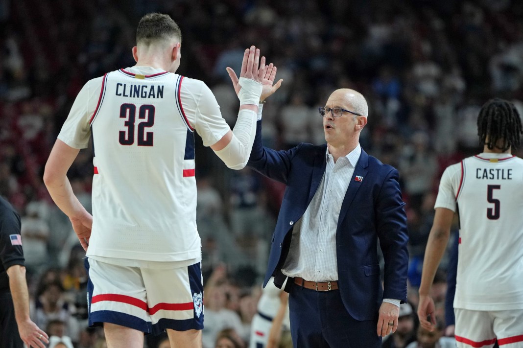 Connecticut Huskies head coach Dan Hurley high fives center Donovan Clingan as he exits the game.