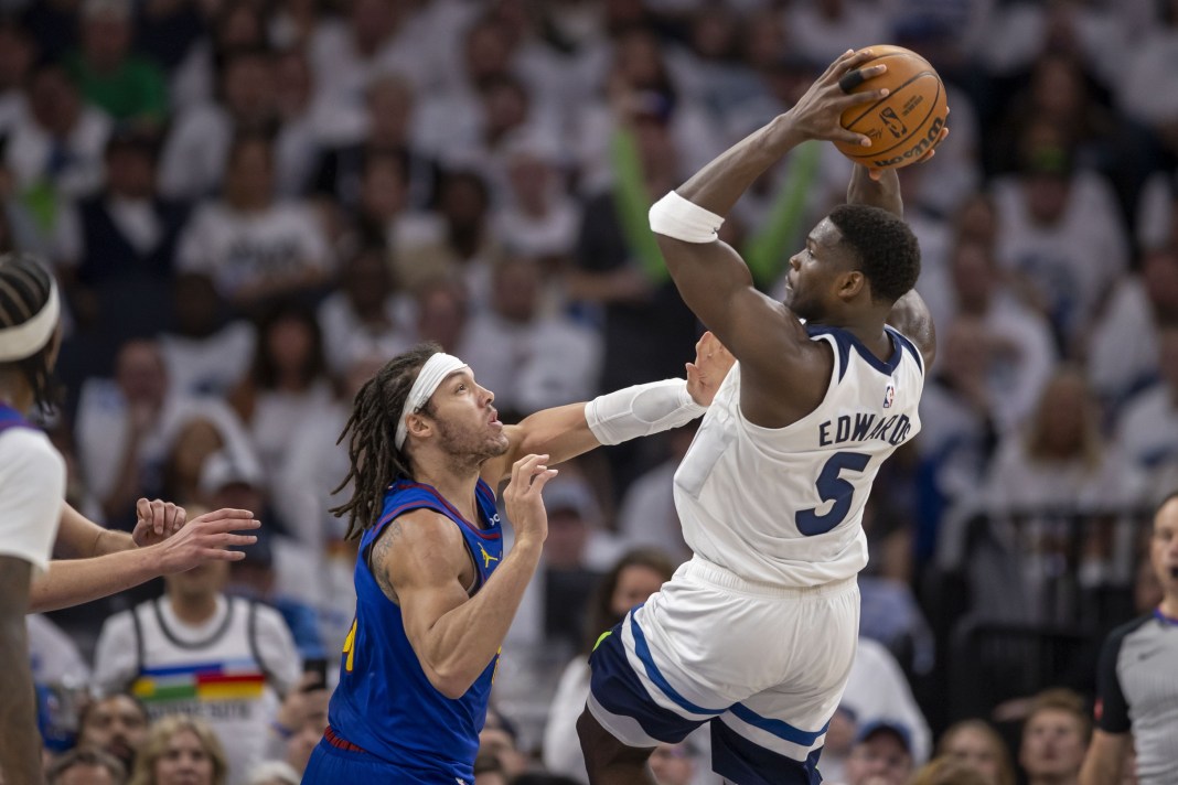 Minnesota Timberwolves guard Anthony Edwards jumps up and attempts to pass the ball in the 2024 NBA playoffs at Target Center.