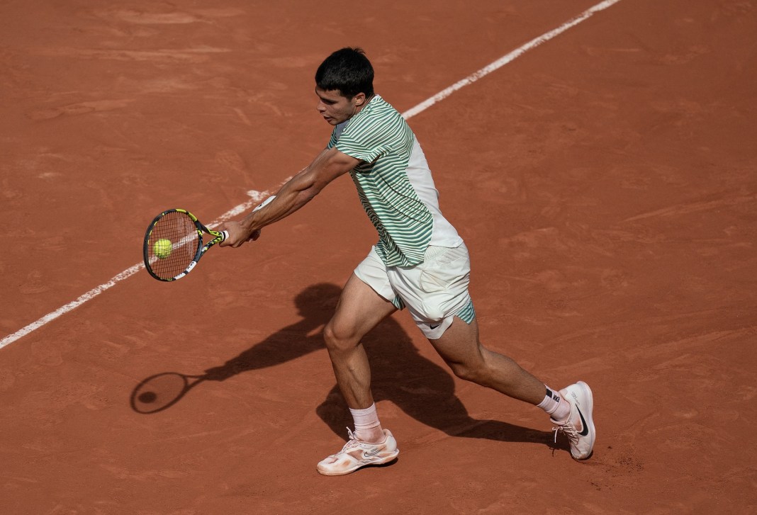 Carlos Alcaraz returns a shot during his semifinal match against Novak Djokovic on day 13 at Stade Roland-Garros.