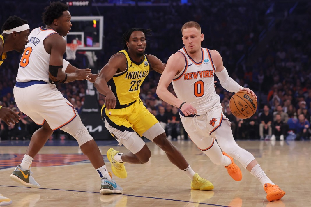 New York Knicks guard Donte DiVincenzo handles the ball against Indiana Pacers forward Aaron Nesmith in game one of the 2024 NBA playoffs.