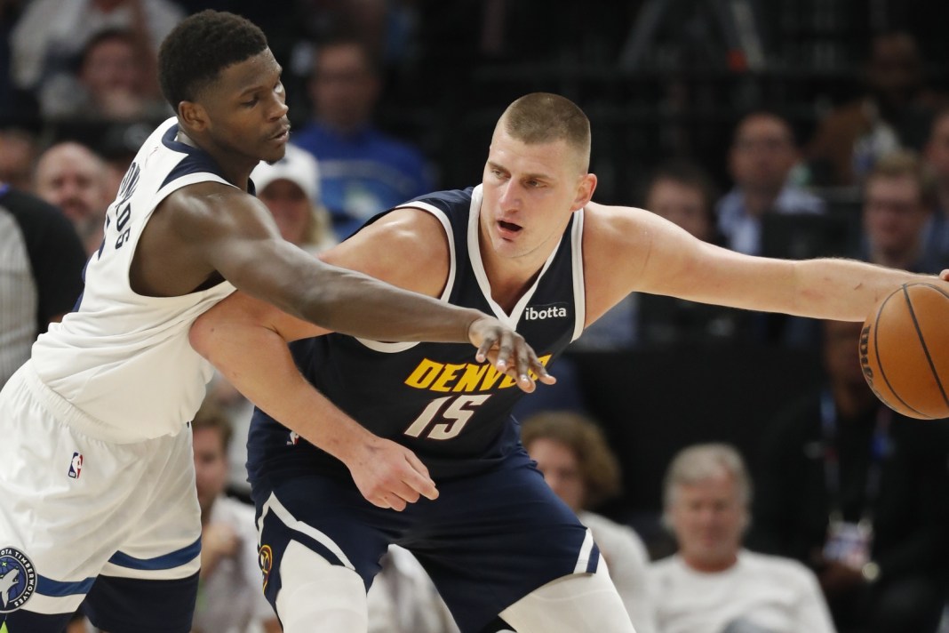 Denver Nuggets center Nikola Jokic (15) works around Minnesota Timberwolves guard Anthony Edwards (5)