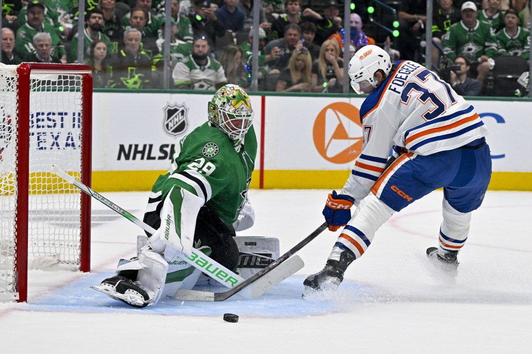 Dallas Stars goaltender Jake Oettinger turns aside a shot by Edmonton Oilers left wing Warren Foegele during the 2024 Stanley Cup Playoffs.