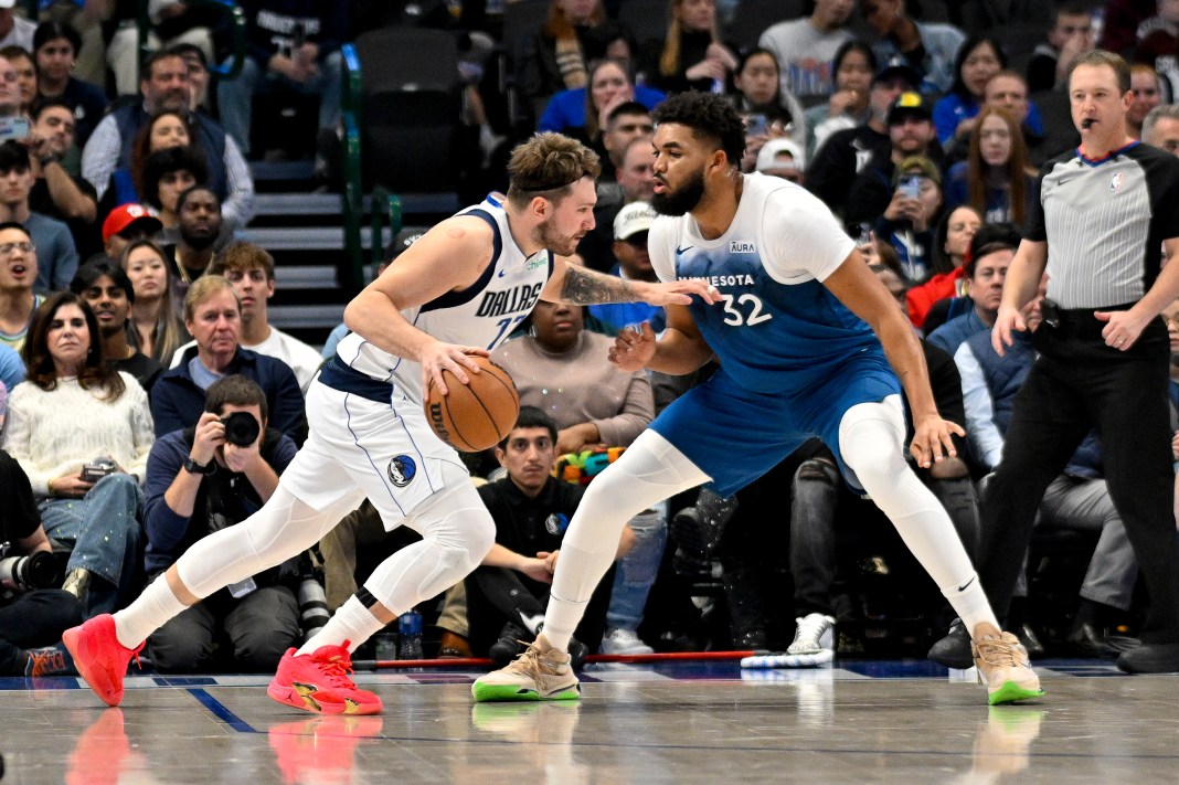 Dallas Mavericks guard Luka Doncic (77) drives to the basket past Minnesota Timberwolves center Karl-Anthony Towns (32)