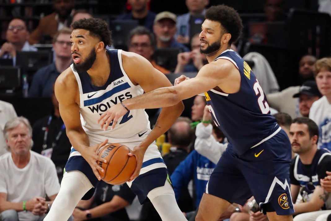 Minnesota Timberwolves forward Karl-Anthony Towns (32) works to get the ball away from Denver Nuggets guard Jamal Murray (27)