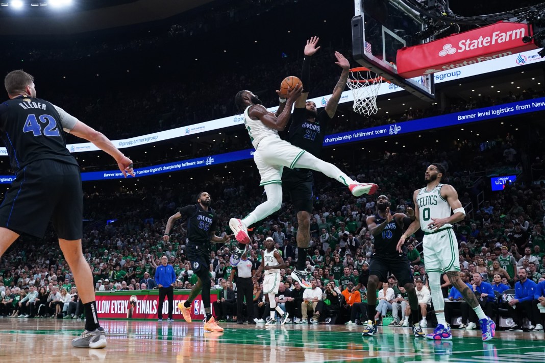 Boston Celtics guard Jaylen Brown shoots the ball against Indiana Pacers center Myles Turner in game one of the 2024 NBA playoffs.