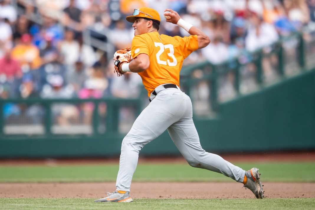 Tennessee's Dean Curley throws to home plate to get Florida State's Jaxson West out during a NCAA College World Series game.