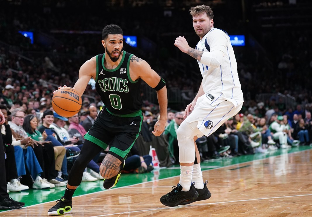 Boston Celtics forward Jayson Tatum drives the ball against Dallas Mavericks guard Luka Doncic in the second half at TD Garden.