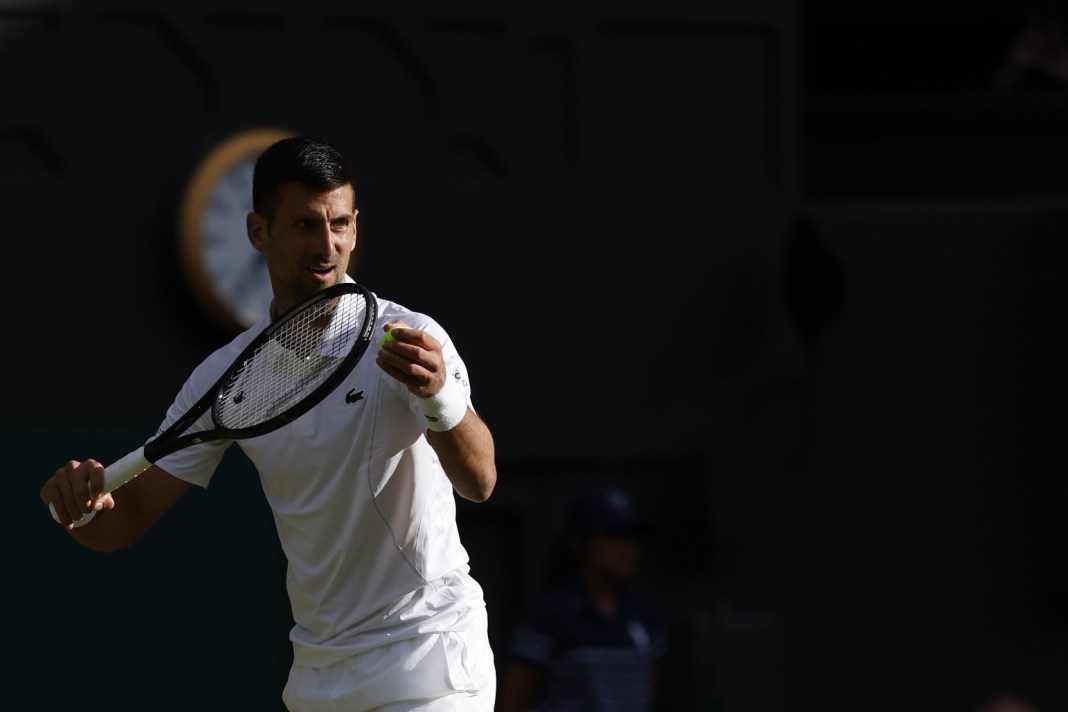 Novak Djokovic gets ready to hit a serve against Alexei Popyrin at Wimbledon.