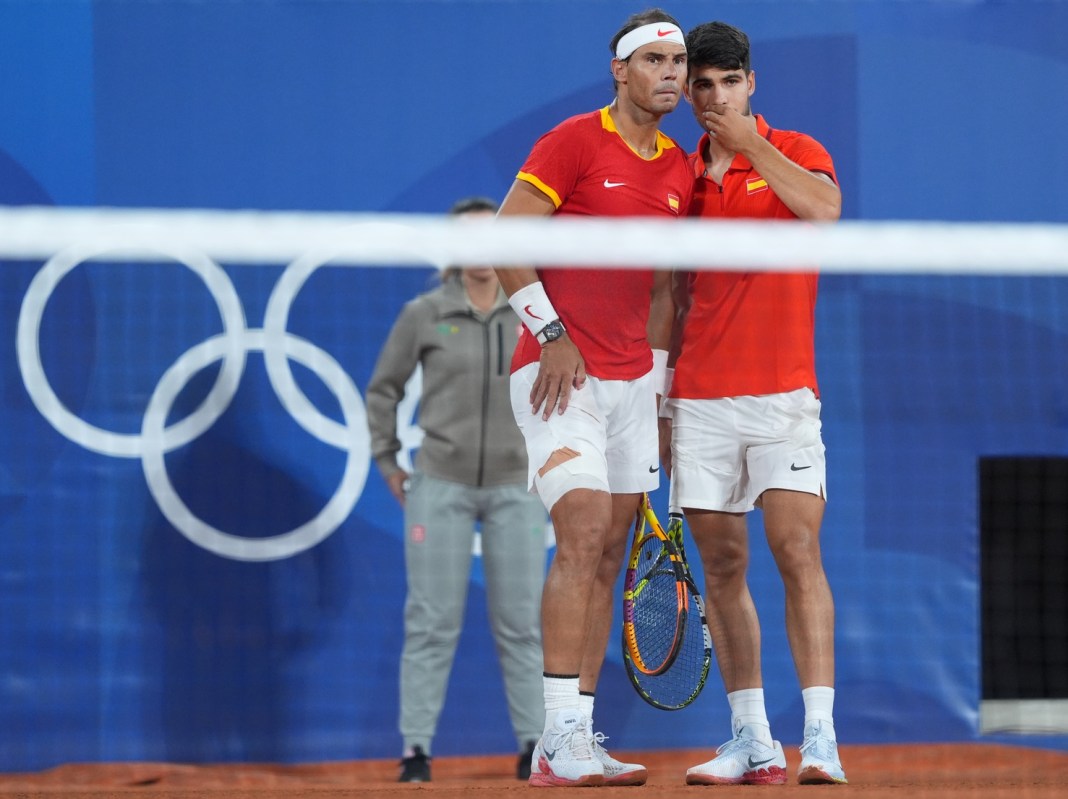 Spain's Rafael Nadal and Carlos Alcaraz strategize in their doubles match at the 2024 Paris Olympics.