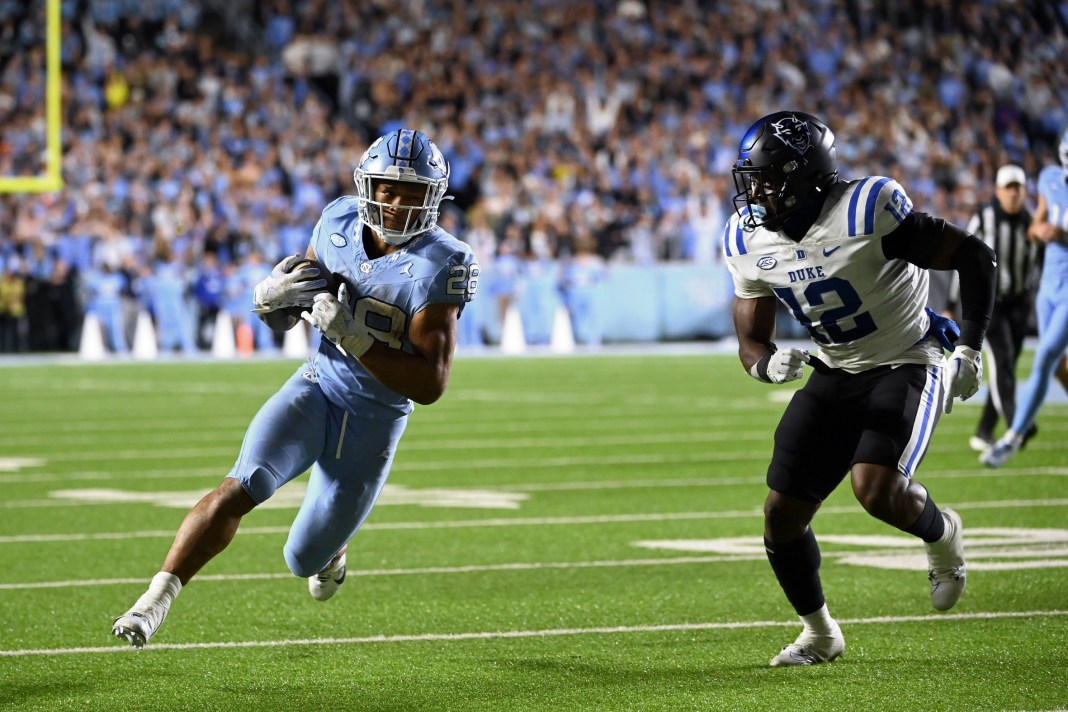 North Carolina Tar Heels running back Omarion Hampton (28) with the ball as Duke Blue Devils linebacker Tre Freeman (12) defends in the first overtime at Kenan Memorial Stadium