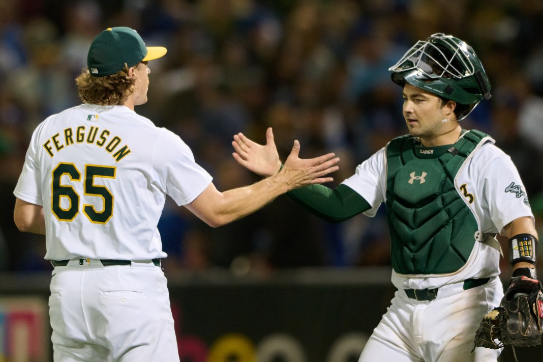 Oakland Athletics pitcher Tyler Ferguson shakes hands with catcher Shea Langeliers after the final out of the game against the Los Angeles Dodgers at Oakland-Alameda County Coliseum.