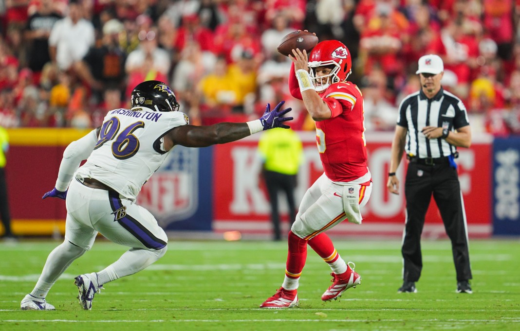 Kansas City Chiefs starting quarterback Patrick Mahomes (15) scrambles from Baltimore Ravens defensive tackle Broderick Washington (96) during the second half at GEHA Field at Arrowhead Stadium