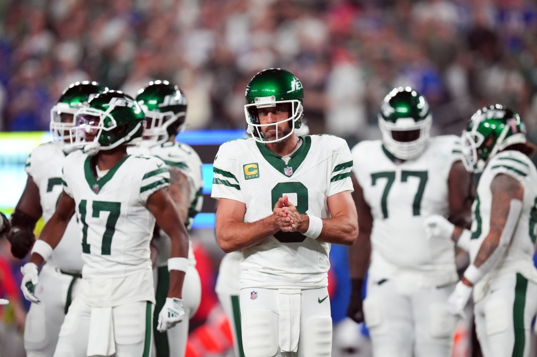 Aaron Rodgers stands with his teammates before the 2023 NFL season opener.