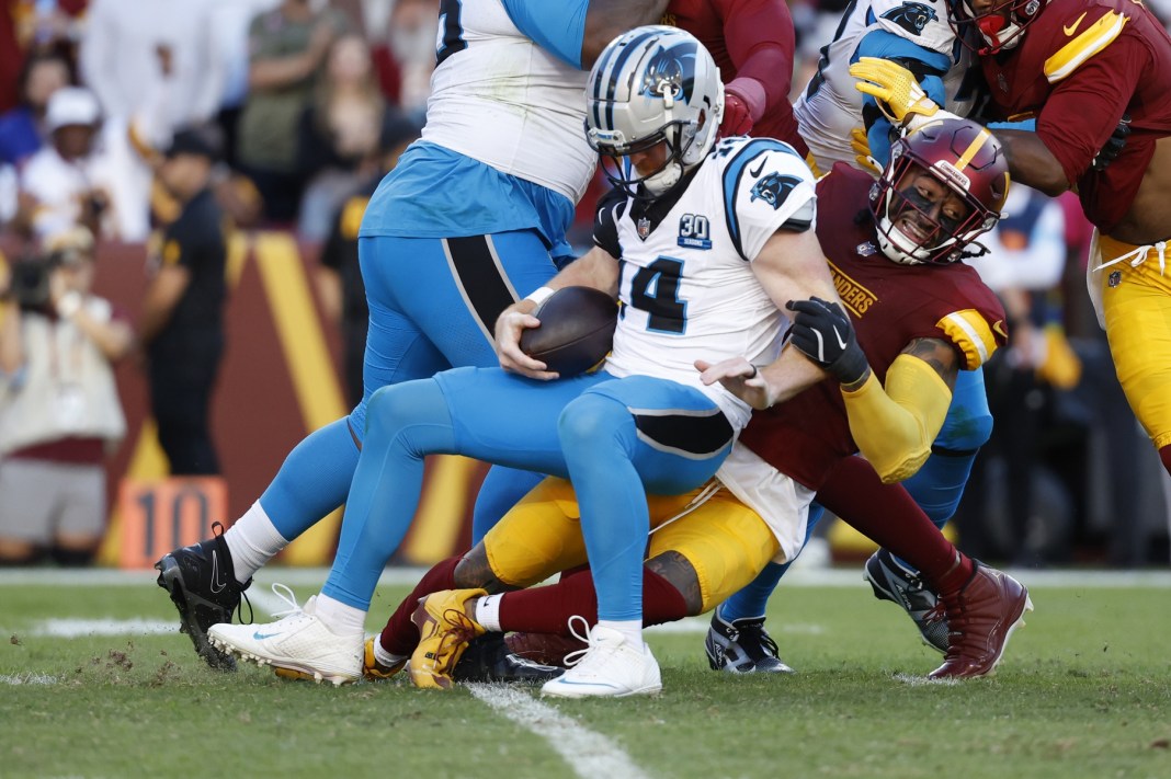 Carolina Panthers quarterback Andy Dalton (14) is sacked by Washington Commanders linebacker Frankie Luvu (4)