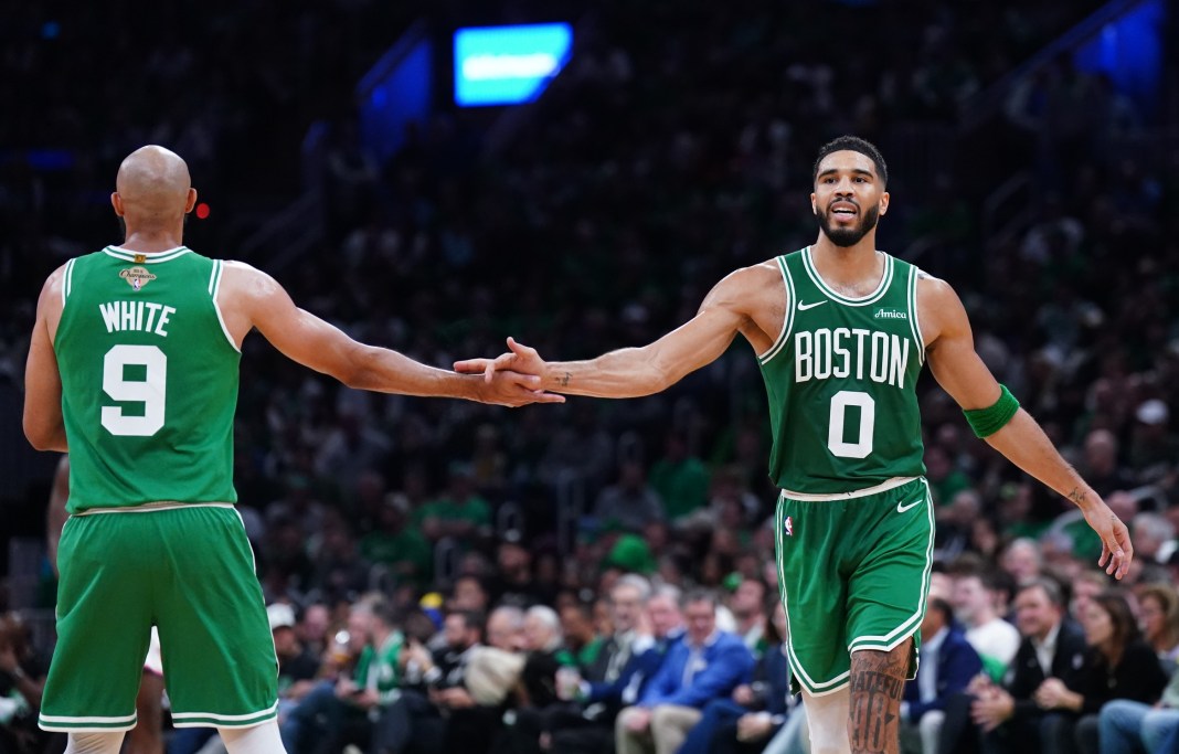 Boston Celtics forward Jayson Tatum (0) reacts with guard Derrick White (9) after a play against the New York Knicks