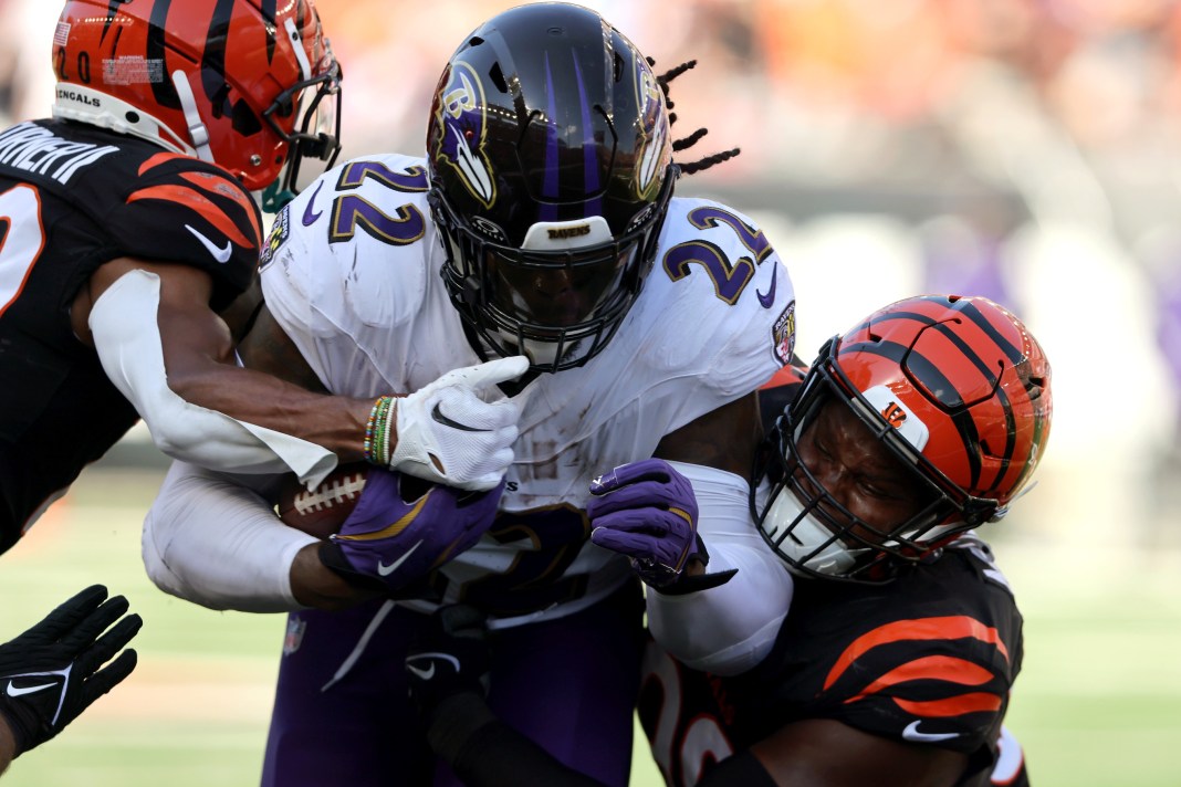 Baltimore Ravens running back Derrick Henry (22) runs the ball as Cincinnati Bengals defensive end Myles Murphy (99) makes the tackle during the second half at Paycor Stadium