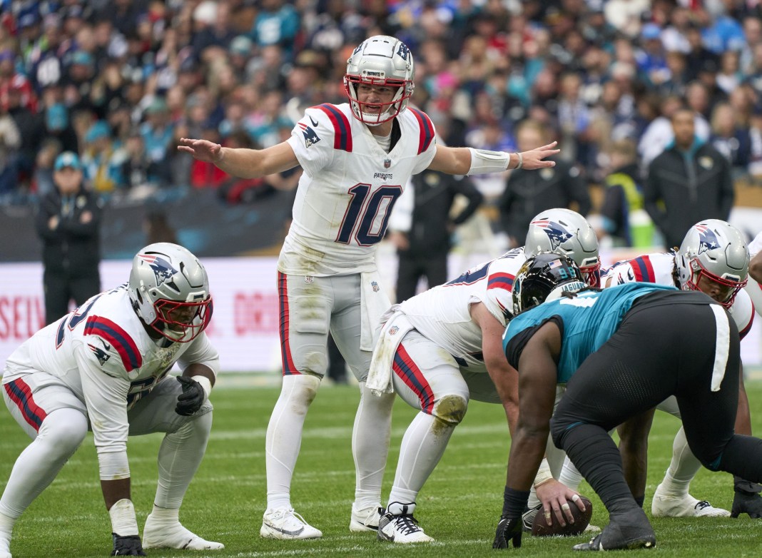 New England Patriots quarterback Drake Maye (10) signs to players in the first half during an NFL International Series game at Wembley Stadium