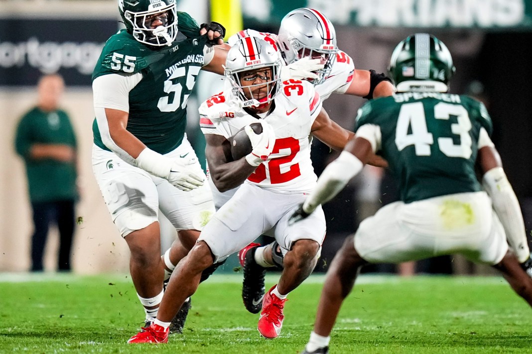 Ohio State Buckeyes running back TreVeyon Henderson runs the ball against Michigan State Spartans defensive back Malik Spencer in the first half at Spartan Stadium on Saturday.