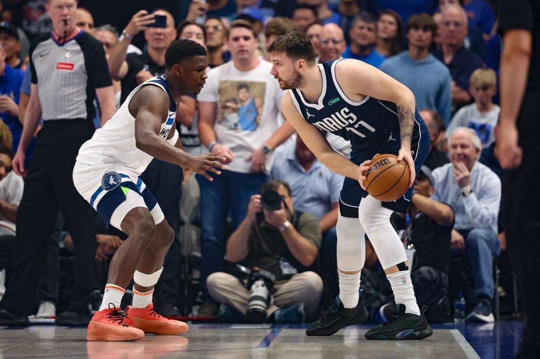 Dallas Mavericks guard Luka Doncic controls the ball as Minnesota Timberwolves guard Anthony Edwards defends.