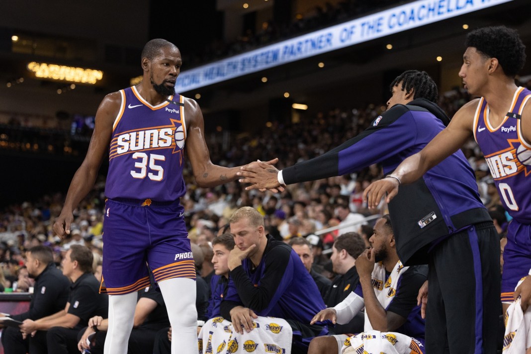 Suns star Kevin Durant greets his teammates after subbing out of a preseason game against the Lakers.