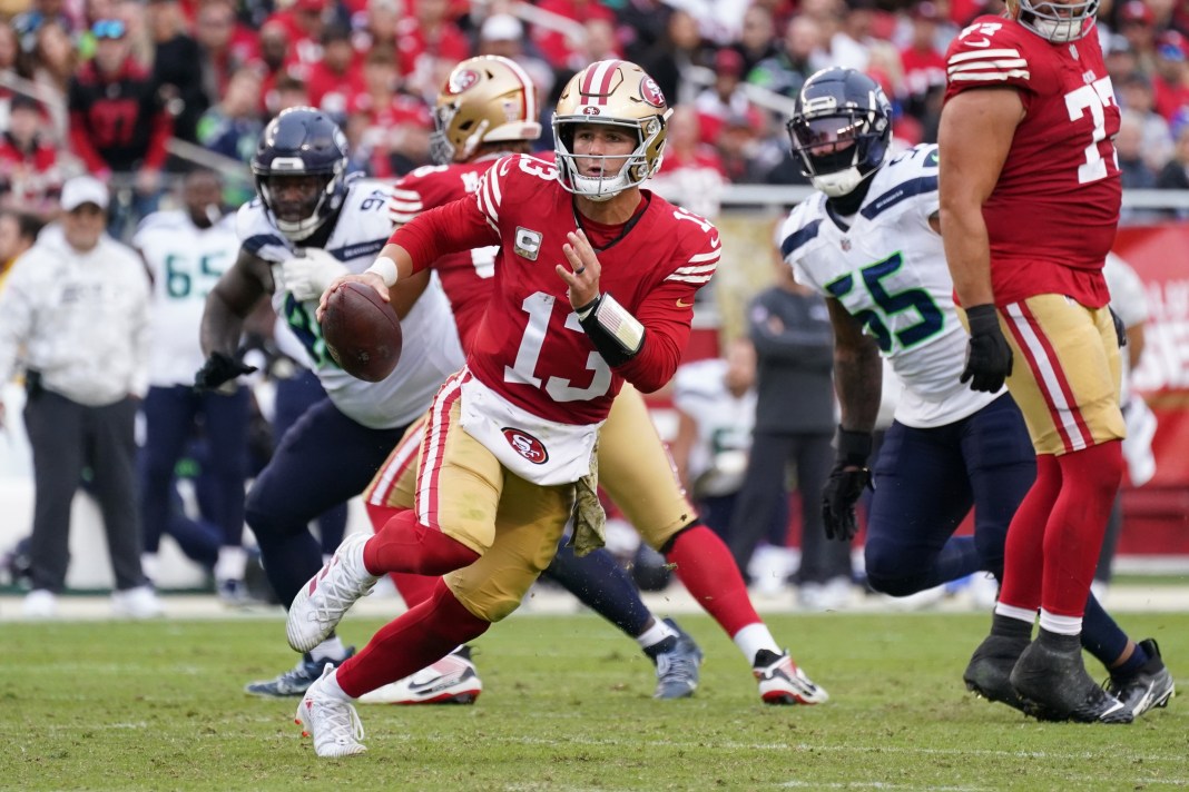 San Francisco 49ers quarterback Brock Purdy runs away from Seattle Seahawks offensive tackle Michael Jerrell