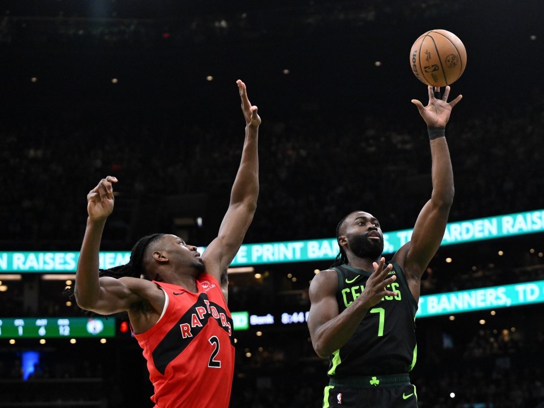 Boston Celtics guard Jaylen Brown attempts a basket against Toronto Raptors forward Jonathan Mogbo