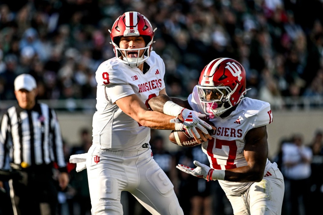 Indiana Hoosiers' Kurtis Rourke, hands the ball off to Ty Son Lawto