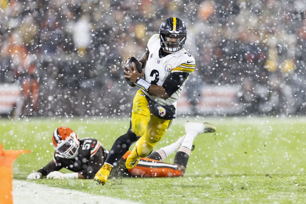 Pittsburgh Steelers quarterback Russell Wilson runs the ball past Cleveland Browns defensive end Isaiah McGuire for a first down