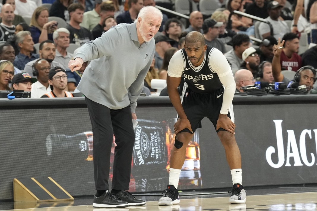 Spurs head coach Gregg Popovich talks to point guard Chris Paul during a game against the Rockets.