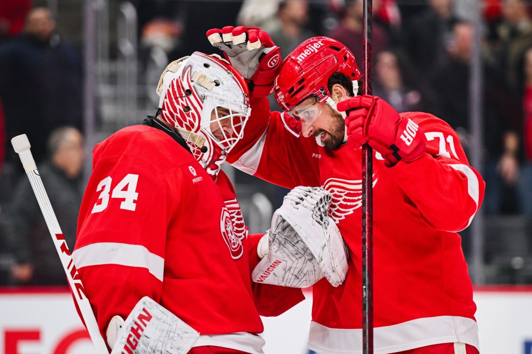 Detroit Red Wings goalie Alex Lyon (34) and center Dylan Larkin (71) celebrate their victory over the Philadelphia Flyers at Little Caesars Arena on December 18, 2024.