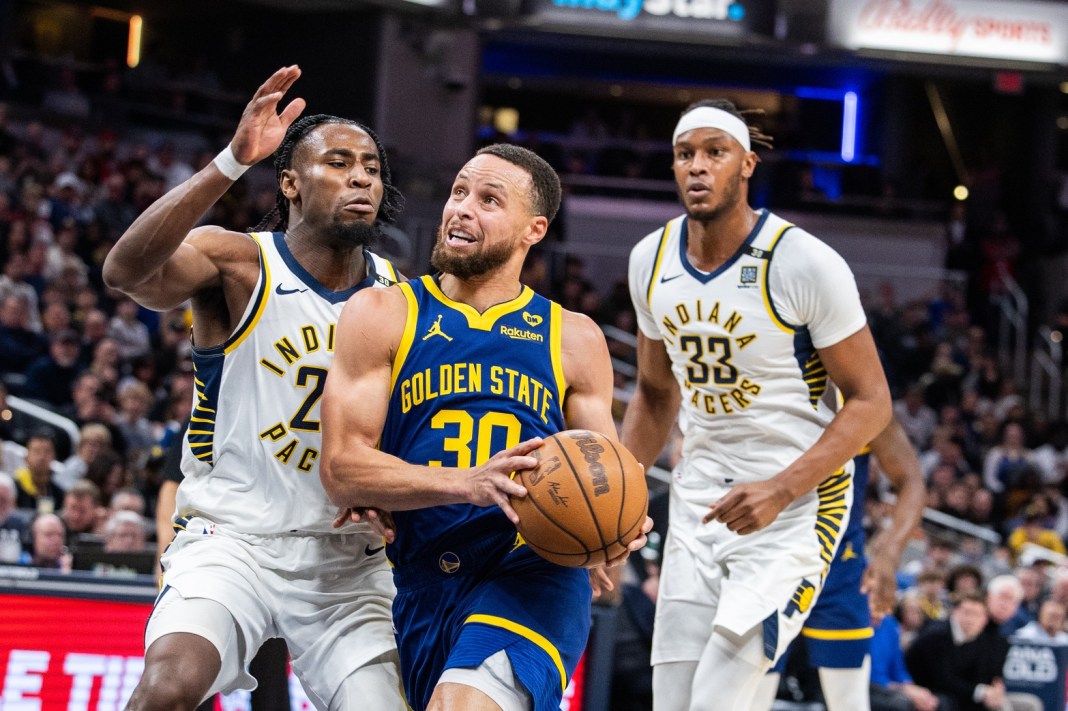 Golden State Warriors guard Stephen Curry drives the lane while Indiana Pacers forward Aaron Nesmith defends