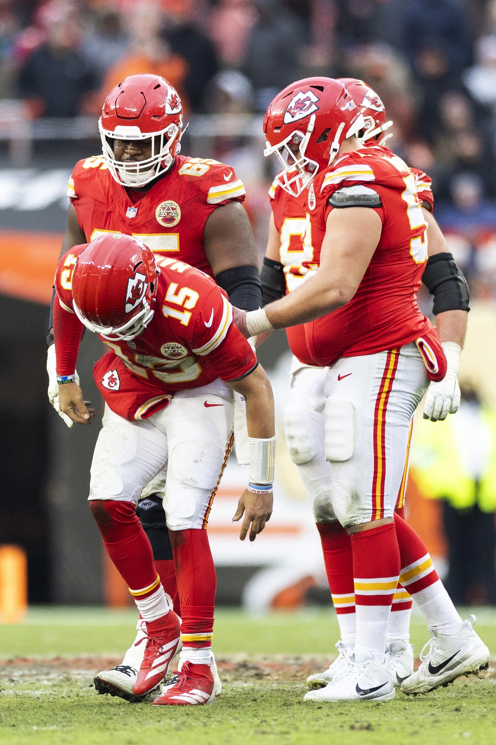 Kansas City Chiefs quarterback Patrick Mahomes (15) limps off the field with help from teammates