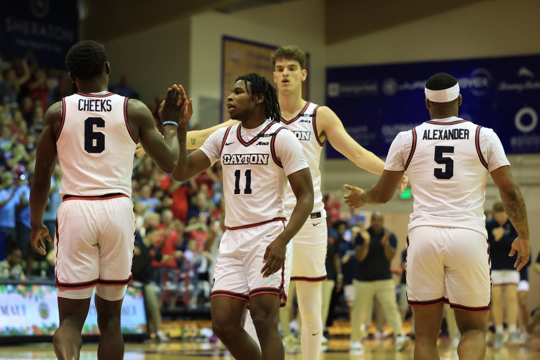 Dayton Flyers teammates celebrate with guard Enoch Cheeks