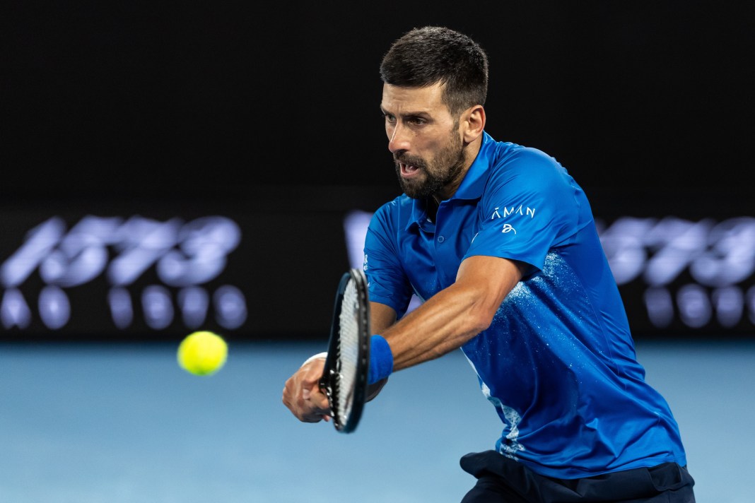 Novak Djokovic hits a backhand against Carlos Alcaraz in the 2025 Australian Open quarterfinals.