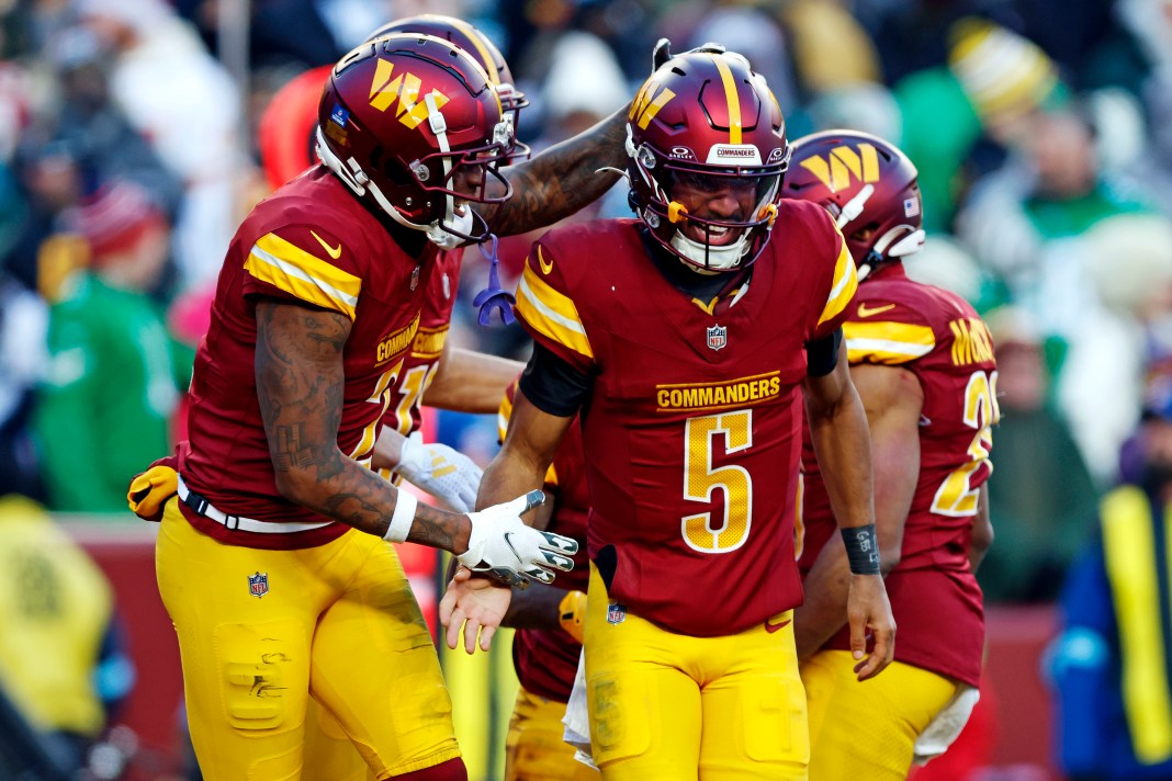 Washington Commanders quarterback Jayden Daniels (5) celebrates after throwing a fourth-quarter touchdown pass against the Philadelphia Eagles at Northwest Stadium on December 22, 2024.