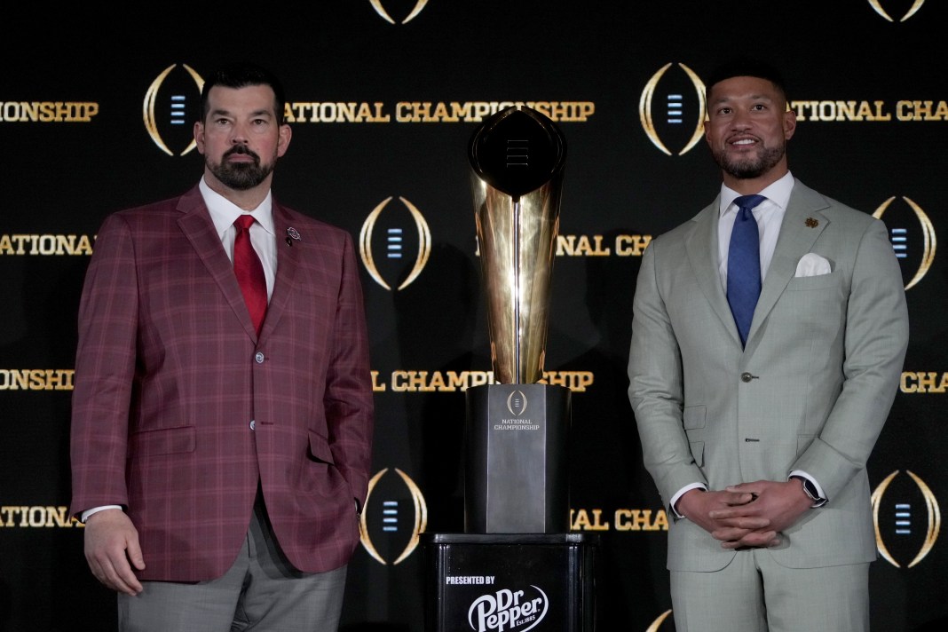 Ohio State head coach Ryan Day and Notre Dame head coach Marcus Freeman pose with the College Football Playoff National Championship trophy at a press conference at The Westin Peachtree Plaza on January 19, 2025