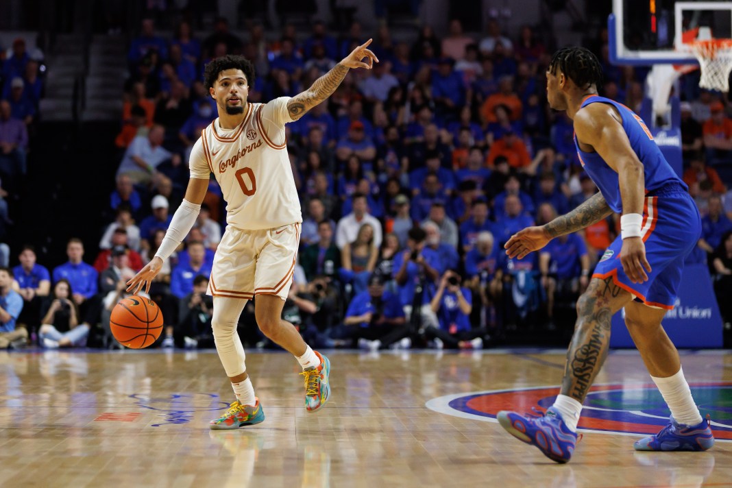 Texas Longhorns guard Jordan Pope (0) gestures while being defended by Florida Gators guard Alijah Martin (15) during the first half at Exactech Arena on January 18, 2025.